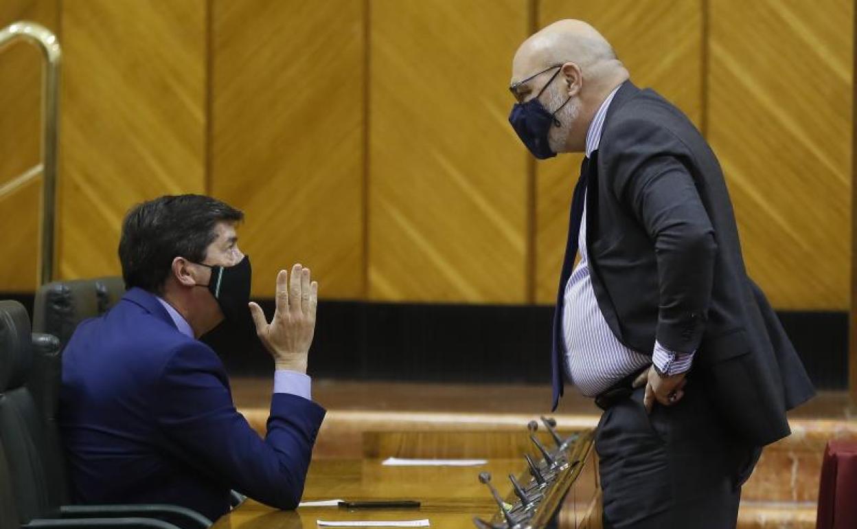 El vicepresidente de la Junta de Andalucía, Juan Marín (Cs) (i), conversa con el portavoz parlamentario de VOX, Alejandro Hernández, en el pleno de la Cámara andaluza. 