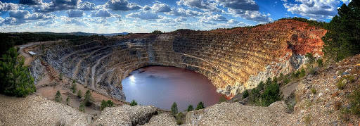 Minas de Riotinto (Huelva) es un pueblo diferente en un entorno distinto, la Cuenca Minera de Riotinto. Este enclave, que abarca los tramos alto y medio del Río Tinto, es único en el mundo, tanto por su belleza cromática como por sus excepcionales condiciones ambientales e históricas. Alrededor del curso alto, se sitúa el mayor yacimiento minero a cielo abierto de Europa. Fue explotado desde los tartesos y sobre todo, por los romanos.