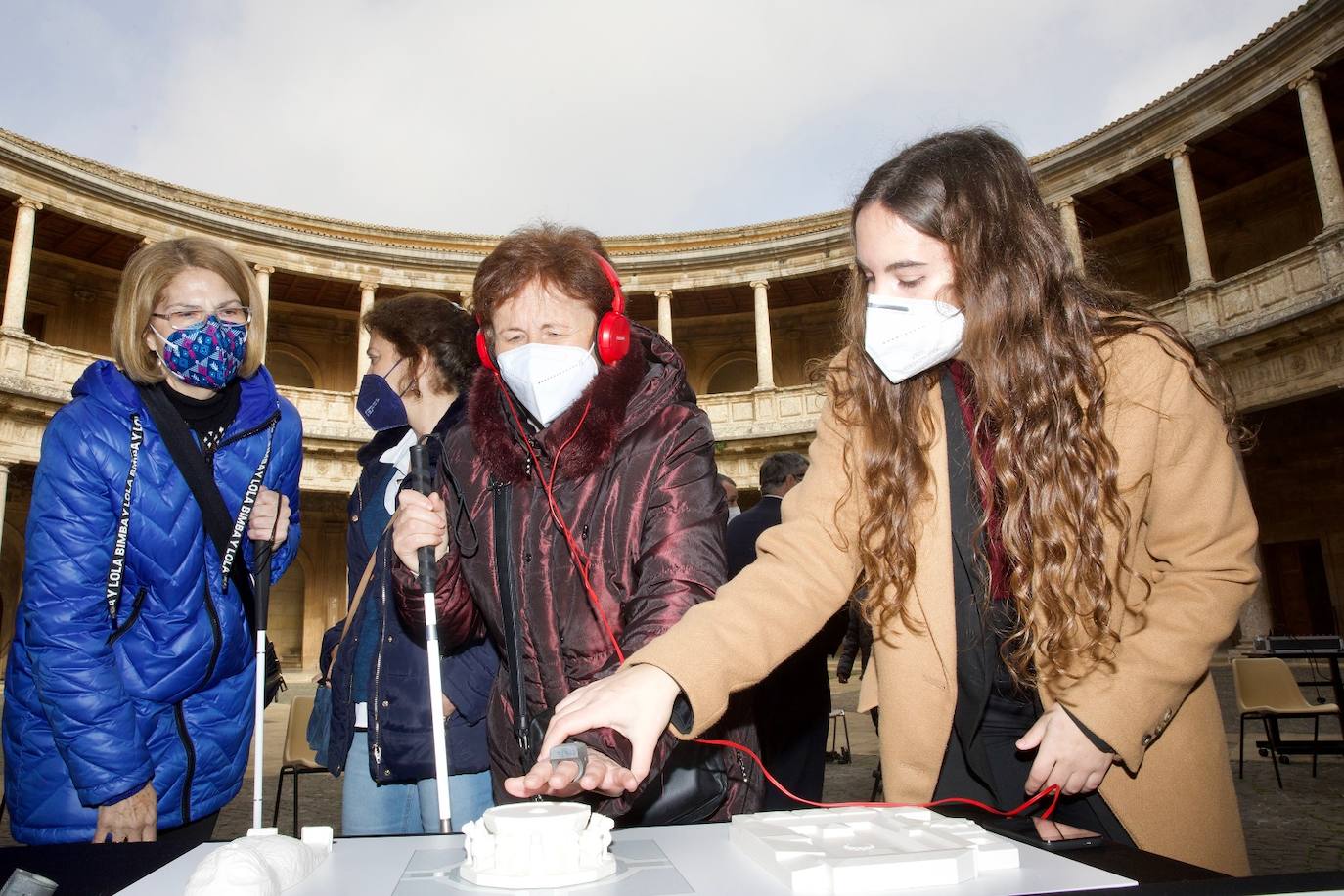 Una señora invidente prueba durante la presentación el sistema piloto que permite conocer el Patio de los Leones. 