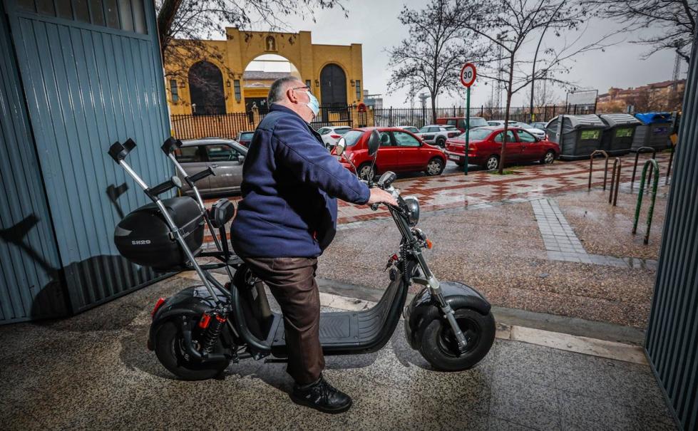 Juan, subido en su moto eléctrica, aparcada en la cochera de la familia en el Zaidín. 