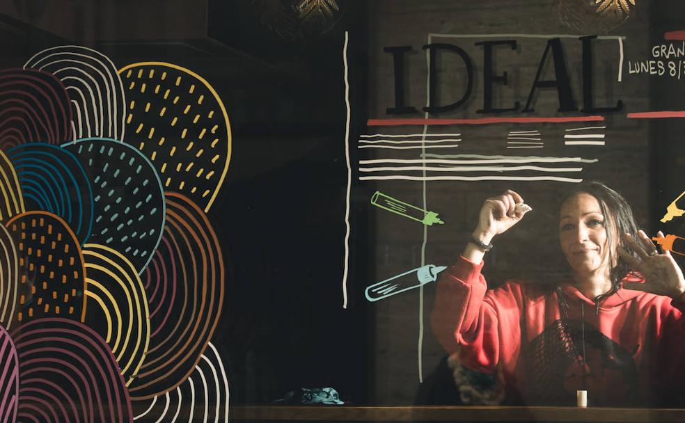 Mamen Rivas pinta el escaparate del pub Paripé con sus rotuladores. 