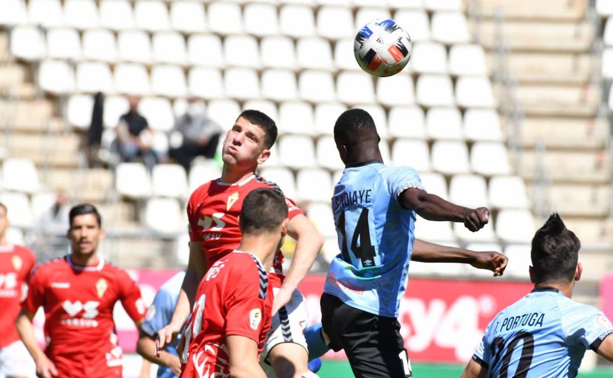 Sana N'Diaye se impone para despejar un balón por el que lucha también Alberto Toril. 
