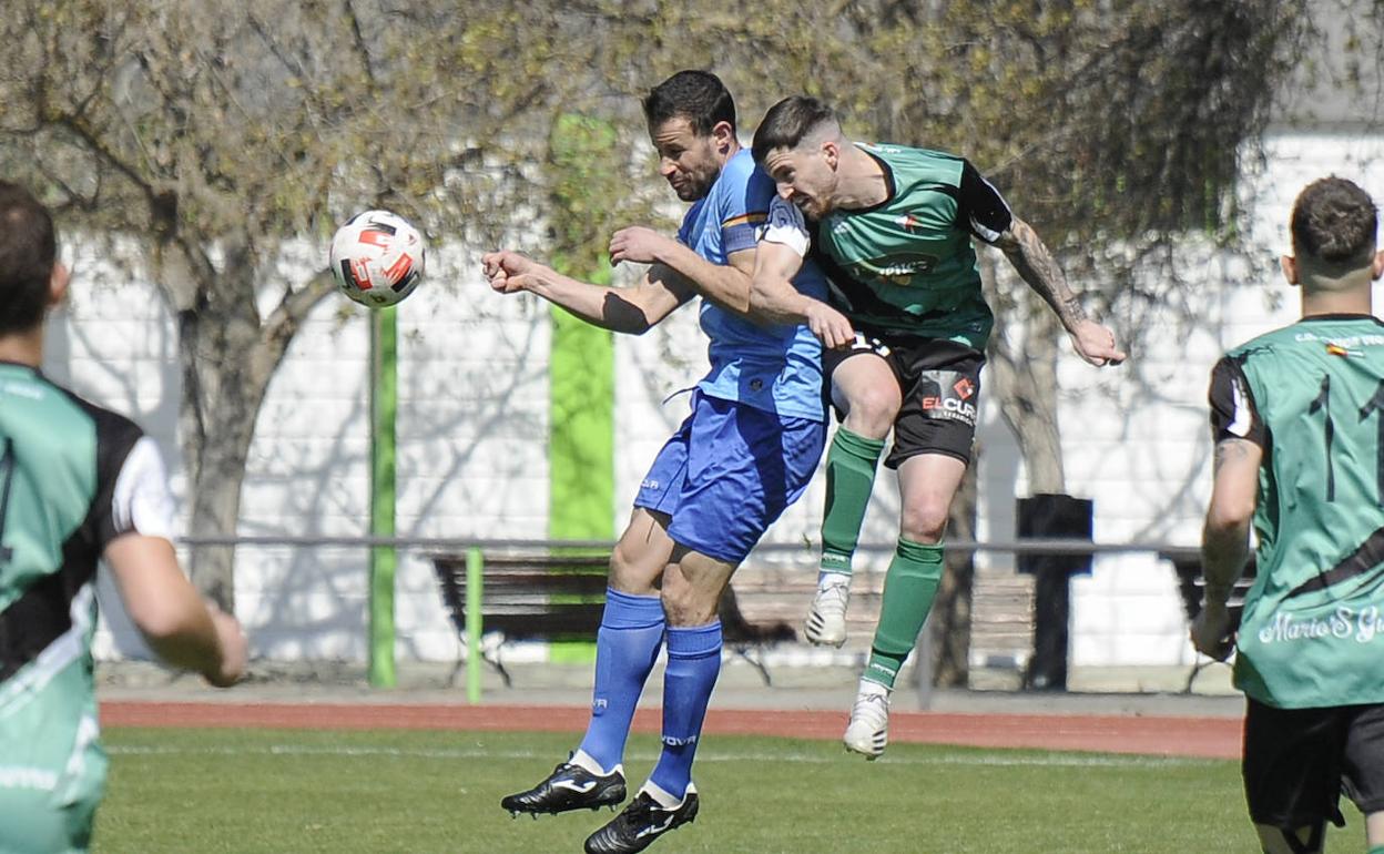 Rubén Martínez y Carli saltan para ganar un balón. 