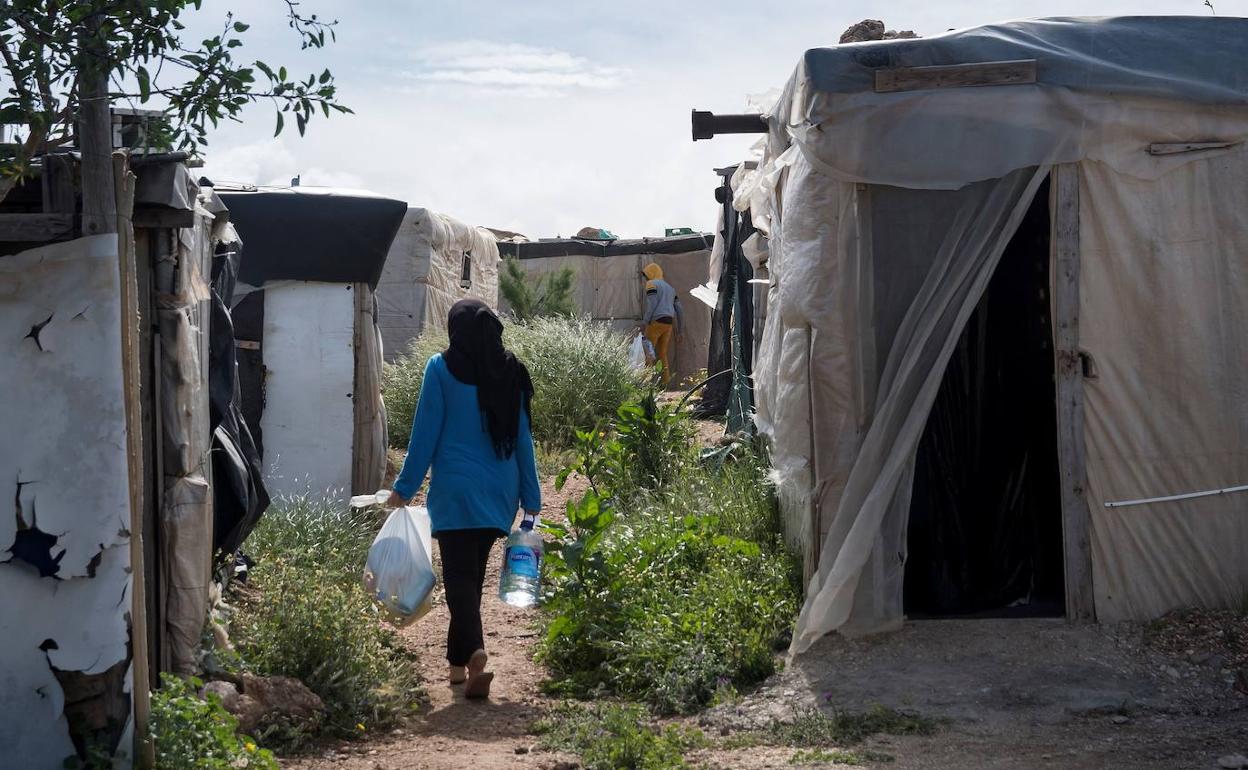 Una mujer camina entre chabolas en uno de los asentamientos del Campo de Níjar.