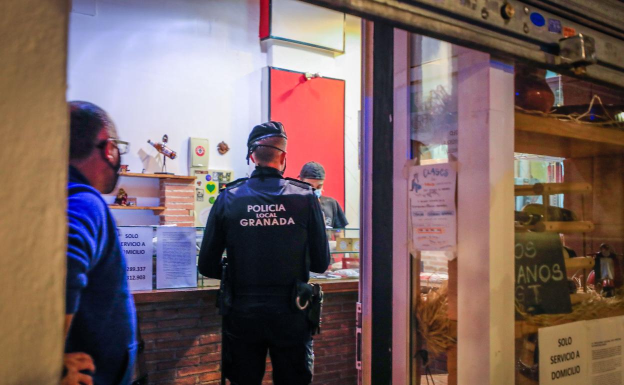 Un policía local durante la inspección a un local de comida para llevar