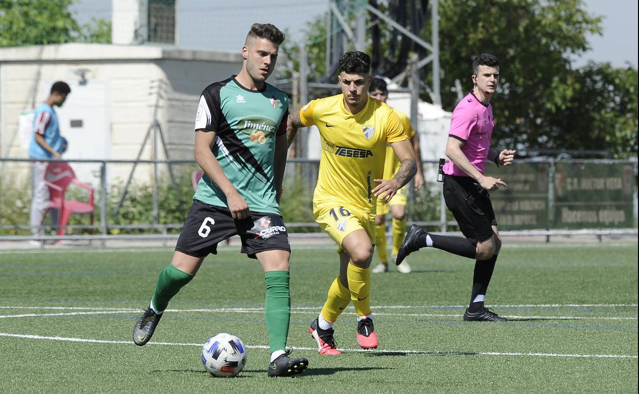 Hurtado retrasa el juego ante la presión de un jugador malaguista. 