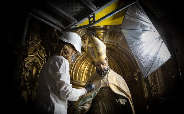 Limpiando la talla de San Celicio. 