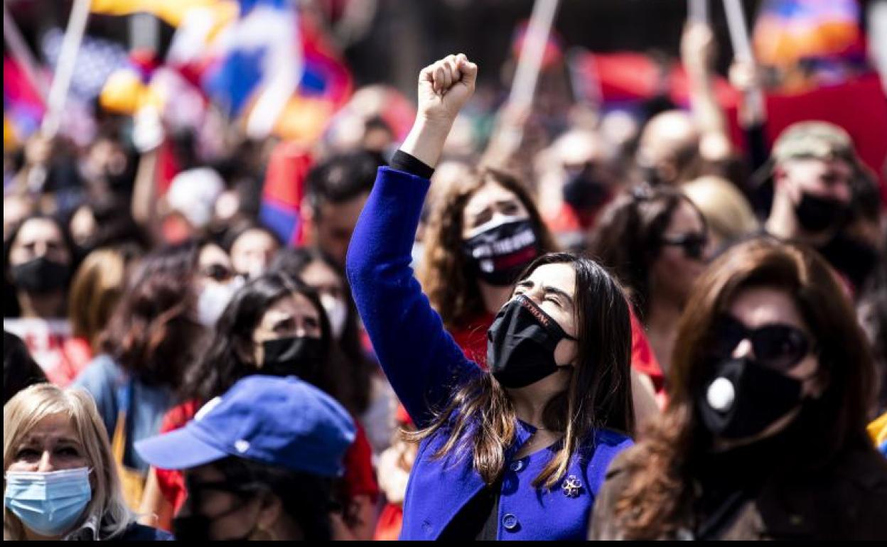 Varias jóvenes con mascarilla participan en Los Ángeles en una protesta contra el genocidio armenio.