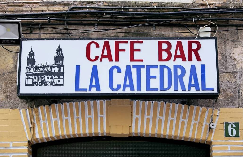 Juan y Carlos posan con un letrero de la Taberna París