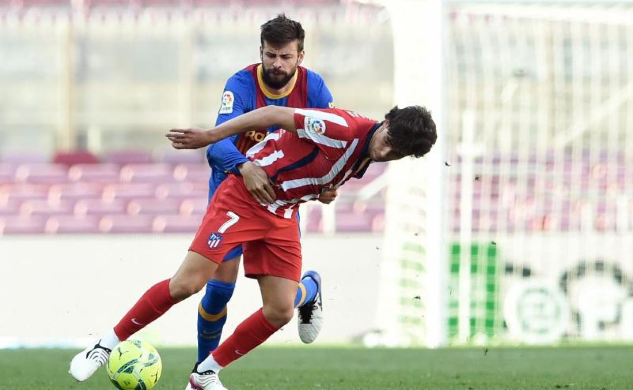 Gerard Piqué sujeta a Joao Félix durante el partido el Camp Nou. 