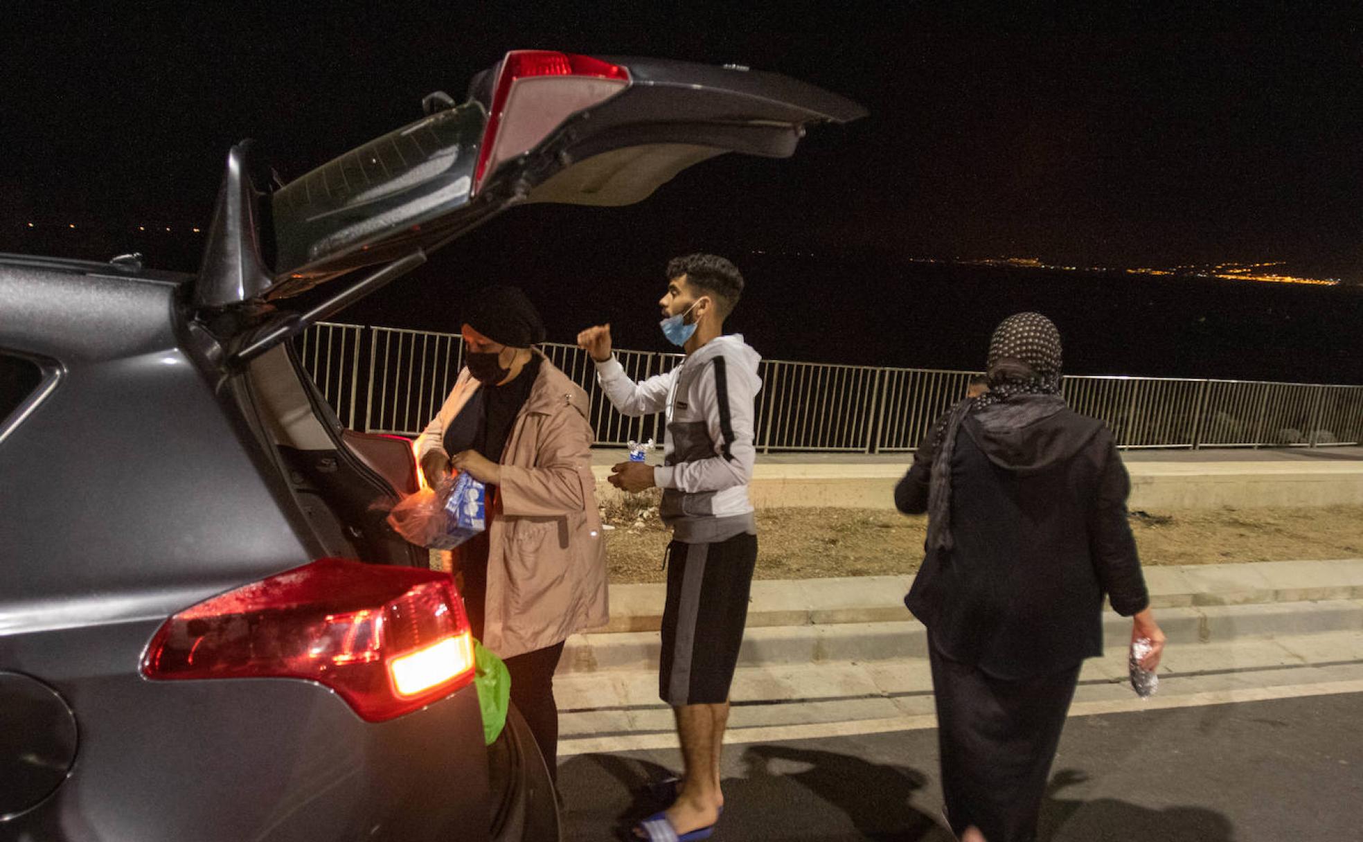 Sabah reparte ayer comida por las calles de Ceuta junto a su amiga Nayat y el joven Abdlghani.
