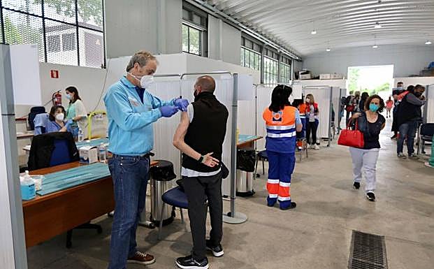 Un enfermero pone una dosis del suero de Moderna en la nave de Bomberos.