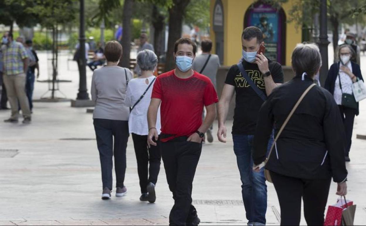 Gente con mascarilla caminando por las calles de Granada.