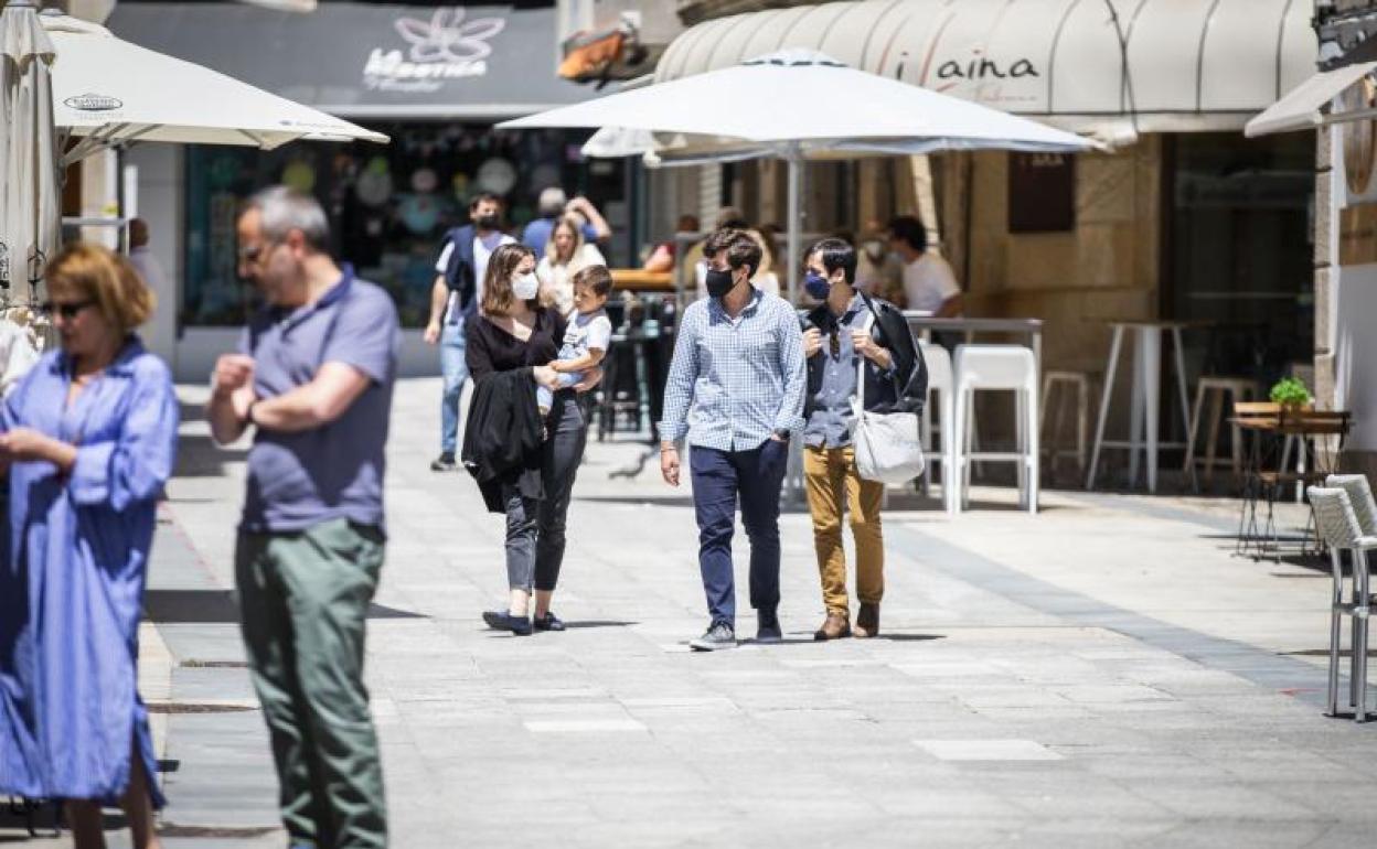 Varias personas en el paseo marítimo de la playa de Sanxenxo.