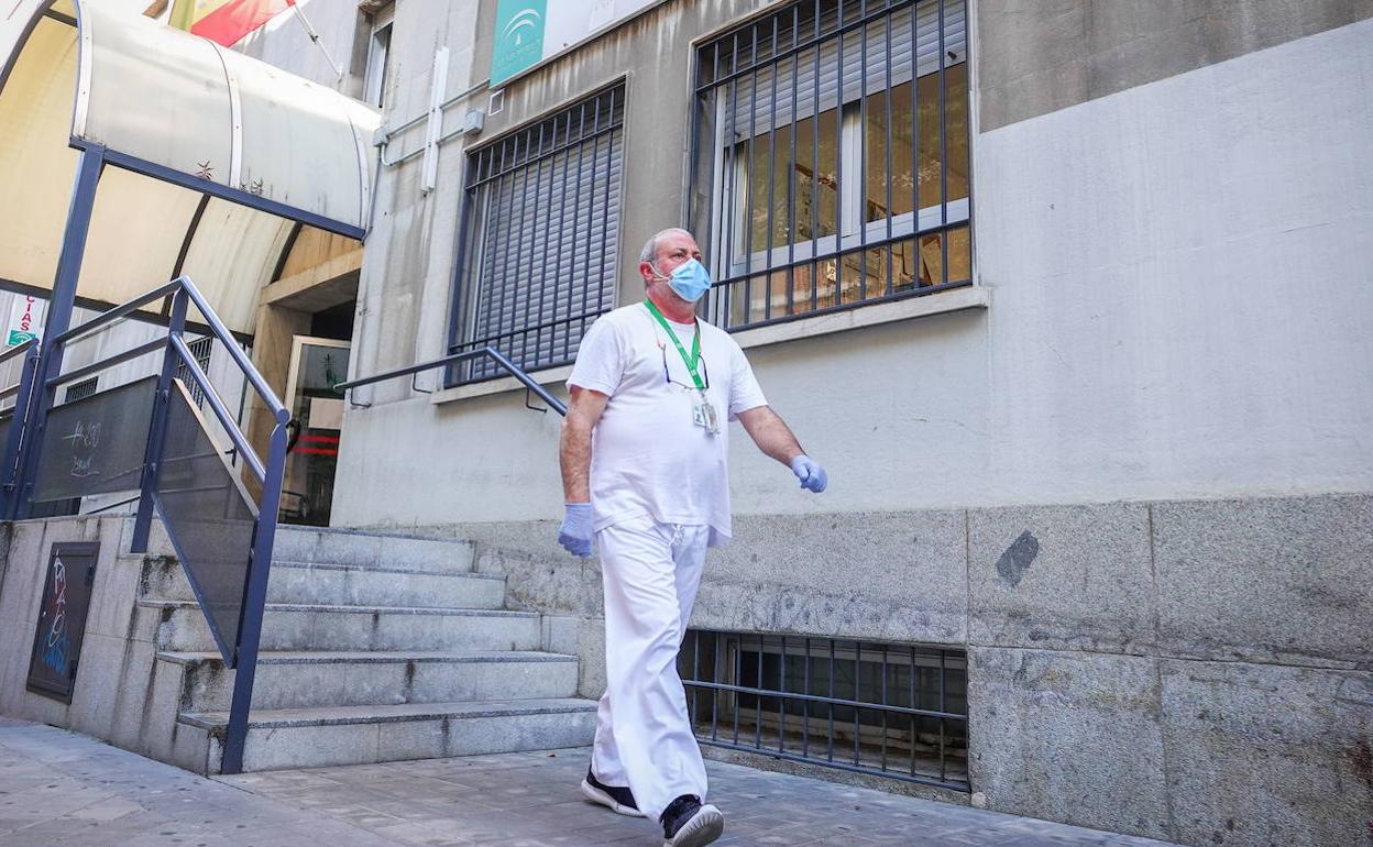 Un trabajador sanitario pasa ante la entrada del centro de salud Gran Capitán.