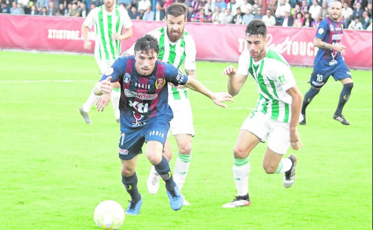 Luis Castillo saliendo de la marca de dos jugadores del Córdoba en un partido de la pasada temporada jugado en Yecla. 