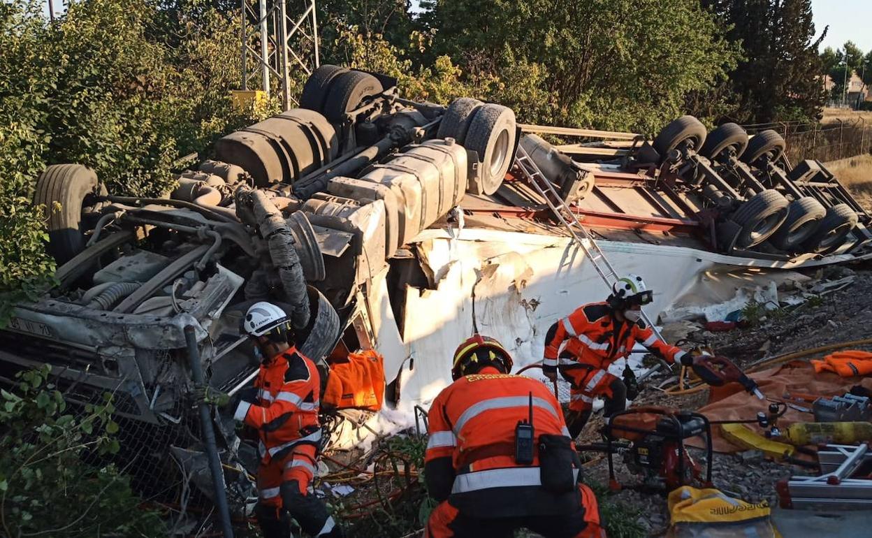 Bomberos trabajando para rescatar al conductor.