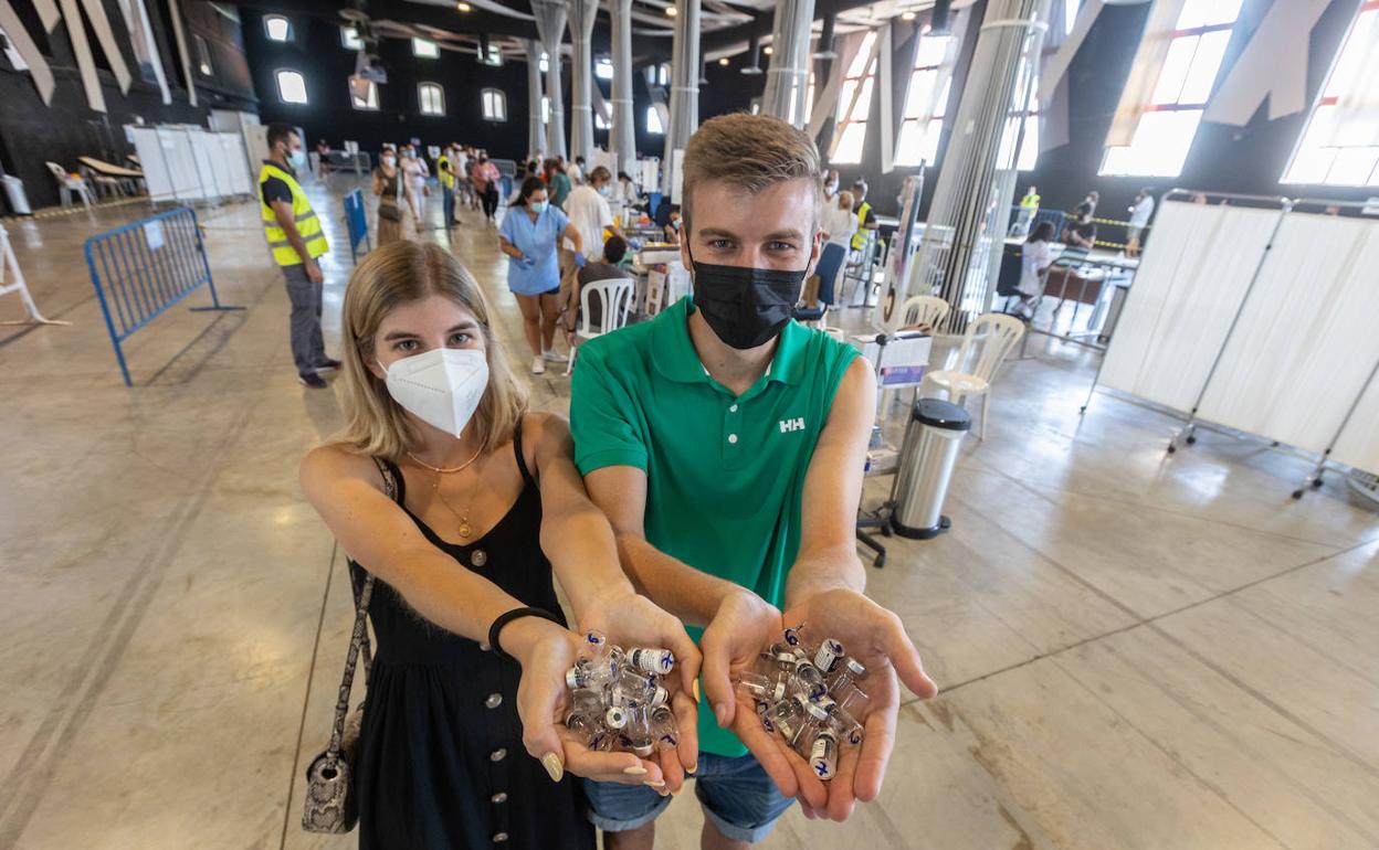 Andrea y Miguel Villena, dos hermanos de 26 y 23 años, sostienen algunos de los viales de Pfizer tras recibir la vacuna.