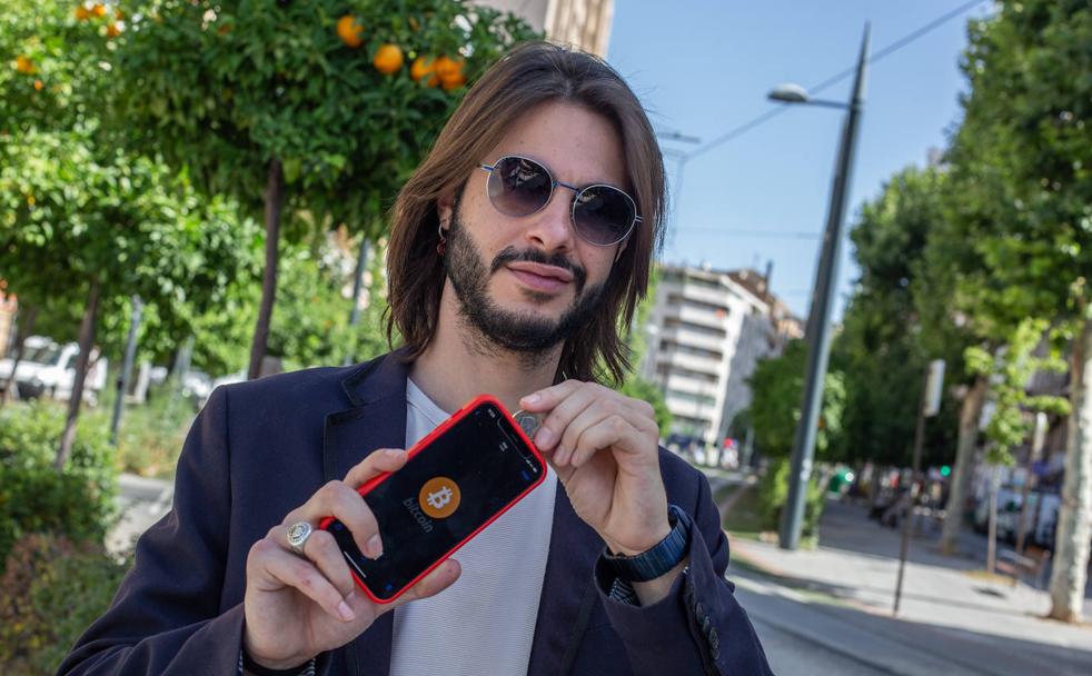 Miguel Gil bromea con un euro en su móvil, con la pantalla de bitcoin. 