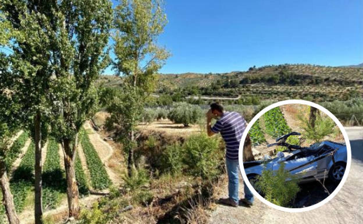 Una persona observa el lugar en el que cayó el coche siniestrado.