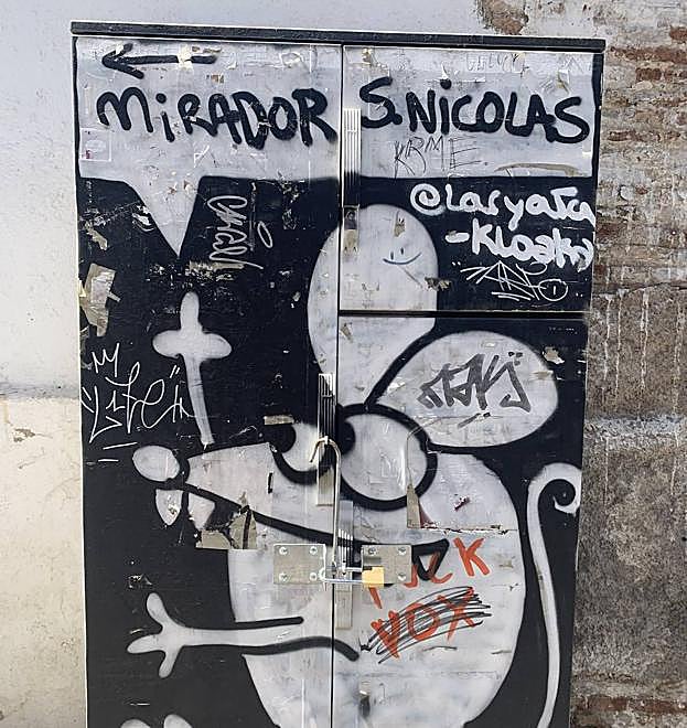 Graffiti que guía a los turistas situado en una calle próxima al Mirador de San Nicolás 
