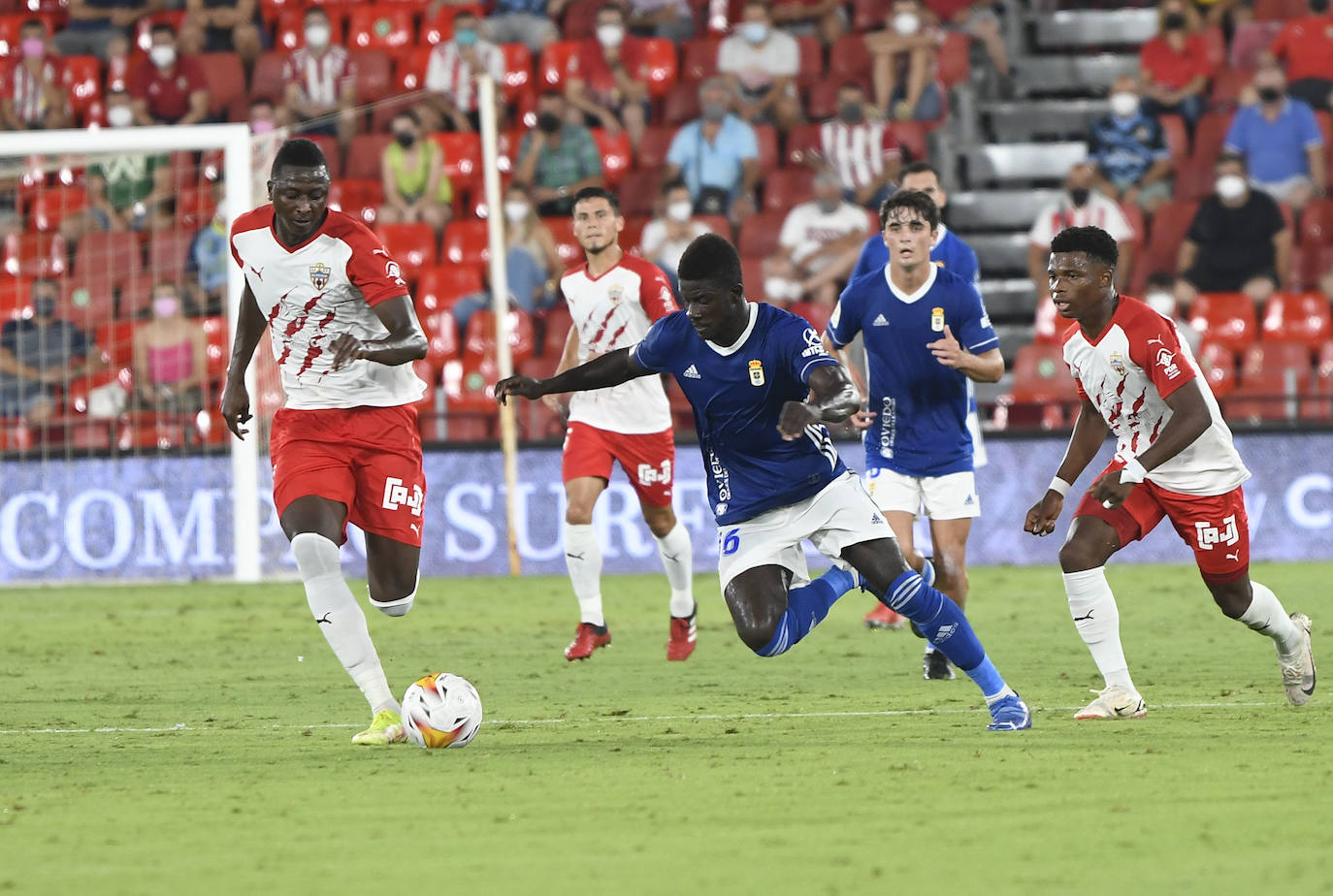 Sadiq Umar conduce el balón perseguido por Obeng, con Largie Ramazani cerca. 