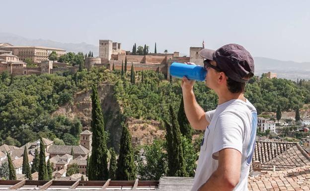 Un turista resiste el calor frente a la Alhambra. 