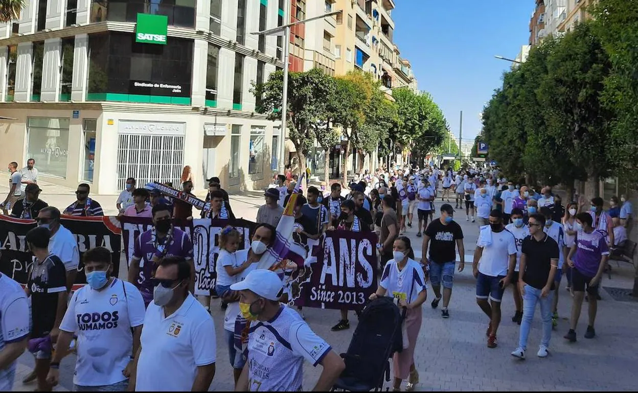 La asociación de veteranos del Real Jaén está repartiendo camisetas en la previa de la marcha. 