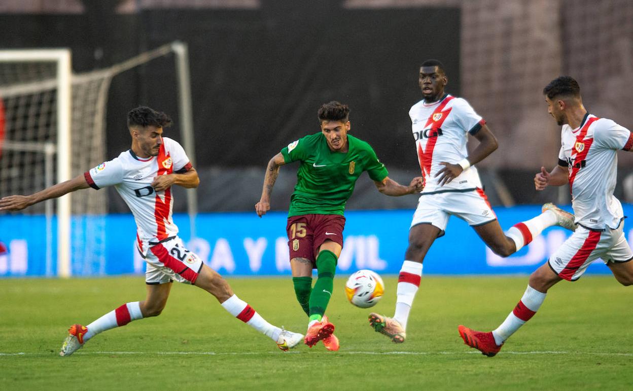 Carlos Neva pierde un balón rodeado de hasta tres contrarios del Rayo Vallecano.