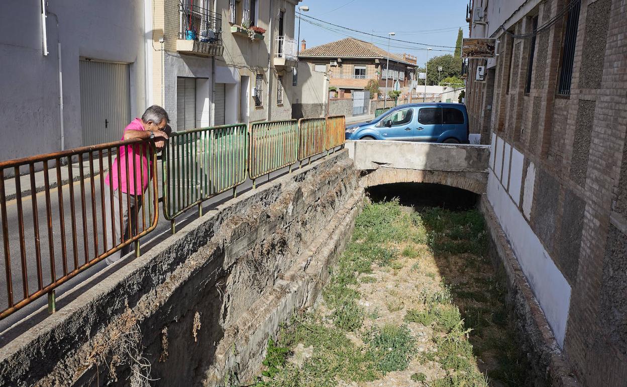 La acequia seca y al descubierto, a su paso por el Paseo de las Palmas, paralelo a la Carretera de la Sierra.