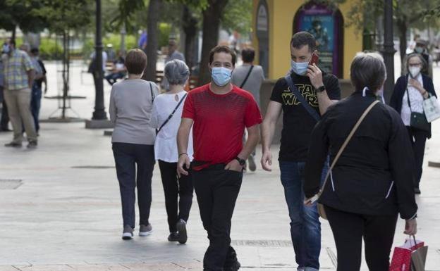 Gente con mascarilla caminando por Granada.