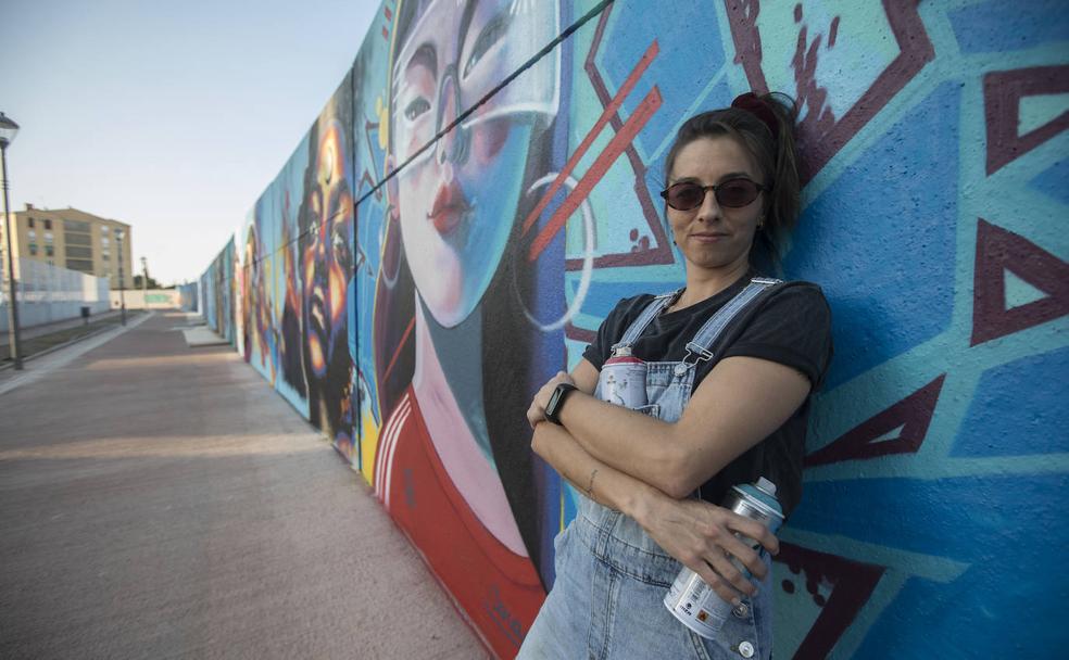 Verónica Soto, junto a su obra, en la gran muralla de La Chana. 