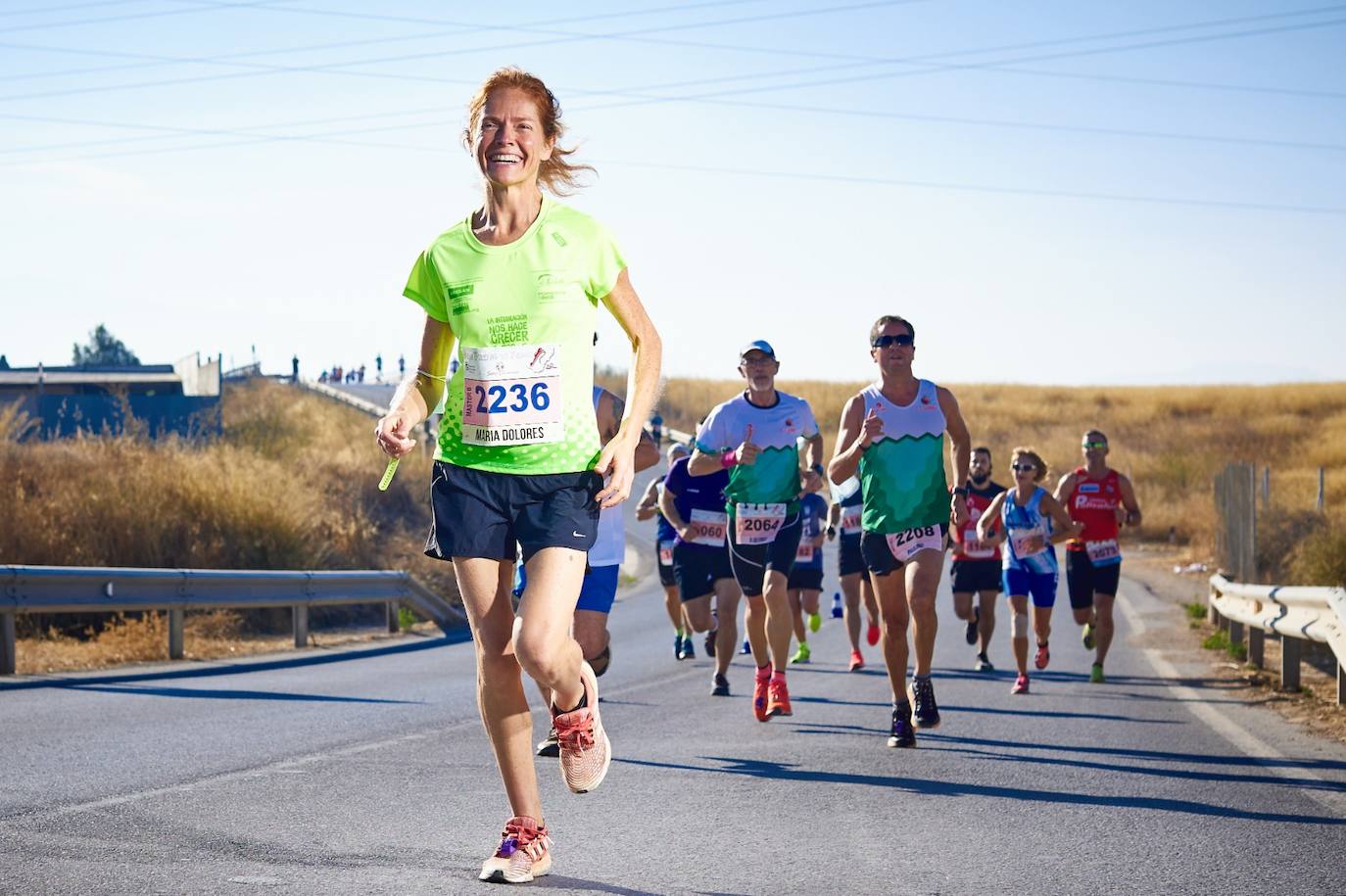 Un pelotón de corredores culmina una bajada. 