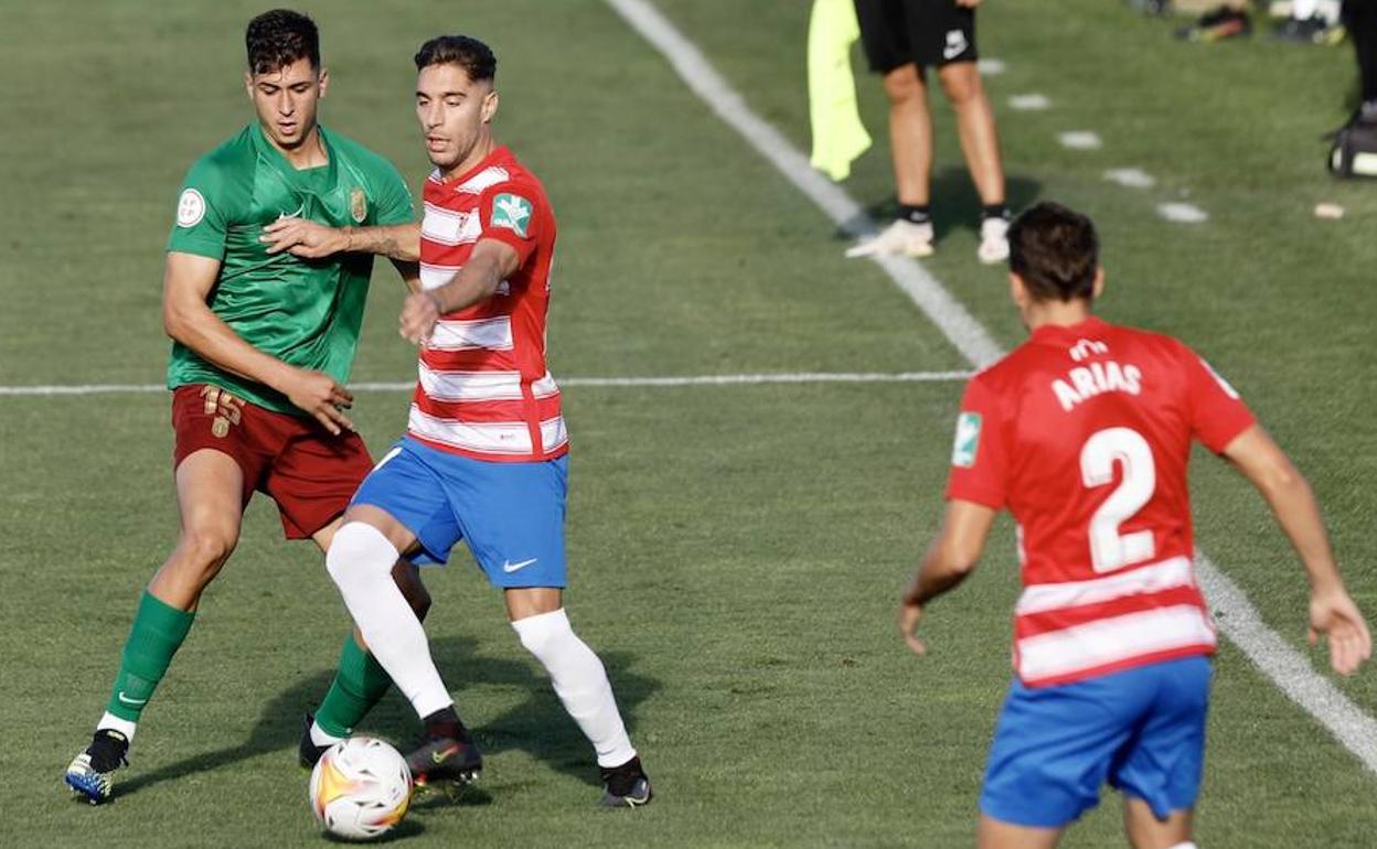 Rochina aguanta un balón ante Torrente en el partidillo contra el filial con el apoyo de Arias. 