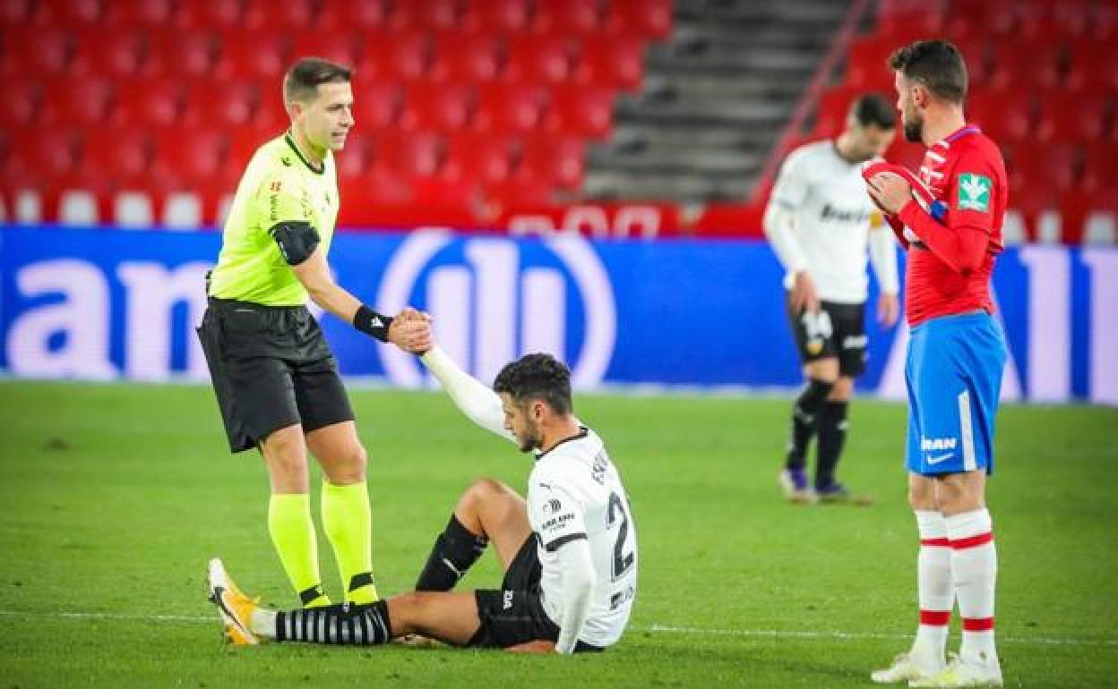 Cordero Vega levanta a un jugador del Valencia del suelo en el último partido que arbitró en Los Cármenes, la temporada pasada. 