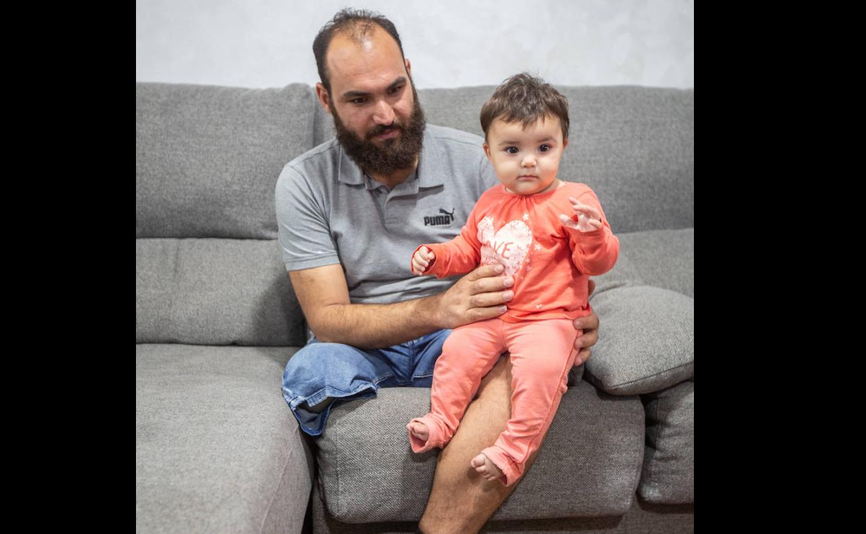 Khaled con su hija pequeña, Martha, en la vivienda social de Granada en la que viven.