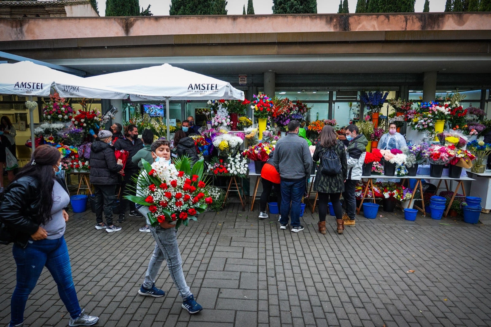 Los granadinos acuden al cementerio con flores en el día de Todos los Santos.