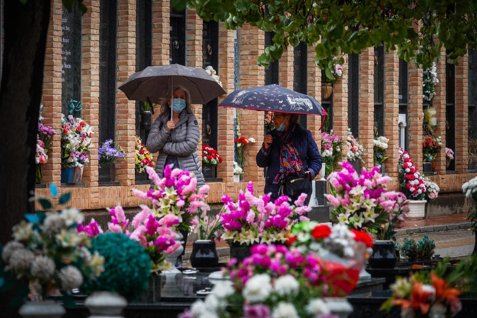 Los granadinos acuden al cementerio con flores en el día de Todos los Santos.