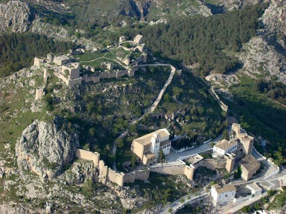 Imagen principal - Dos vistas aéreas del Castillo de Moclín y un detalle de su muralla y una de sus torres.