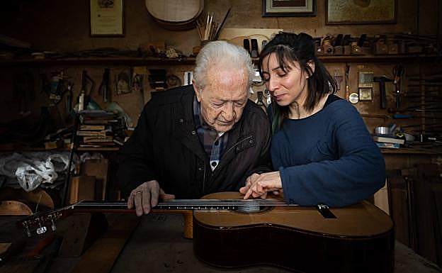 El maestro guitarrero Antonio Marín revisa con Patricia Lazzarini el instrumento con el que ganó el concurso que lleva su nombre.