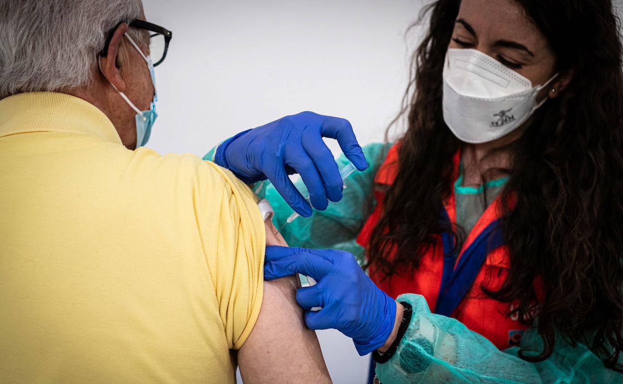 Una enfermera vacuna a un anciano en Granada