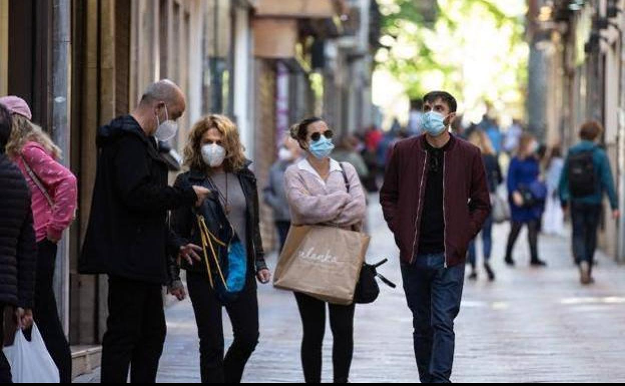 Gente con mascarilla por Granada. 