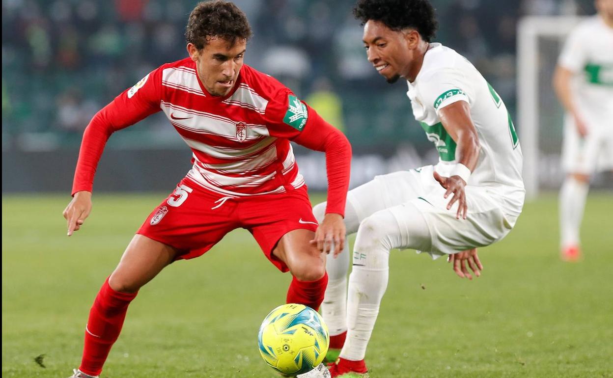 Milla gira para proteger la posesión de Mojica. 