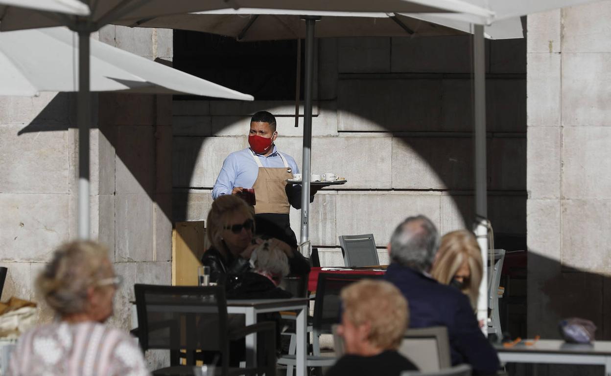 Un empleado de la hostelería atendiendo una terraza