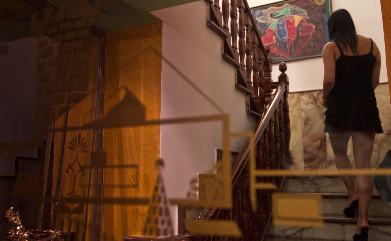 Prostituta aguarda a un cliente en una habitación del club de alterne.