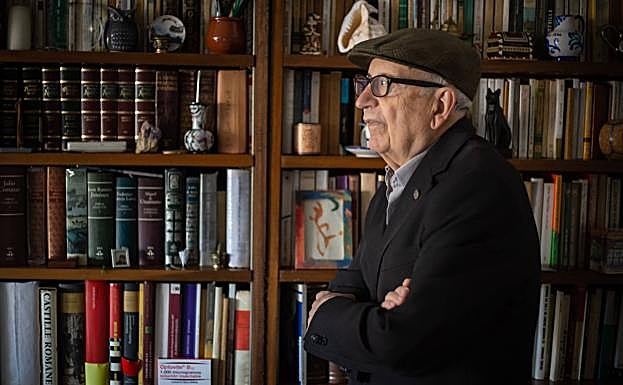 Francisco, junto a una estantería llena de libros en su salón. 