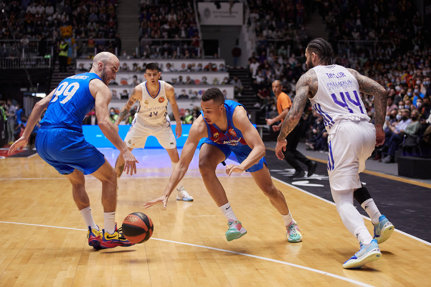 Dante Exum (centro) persigue el balón entre Calathes (99) y Jeff Taylor (44). 