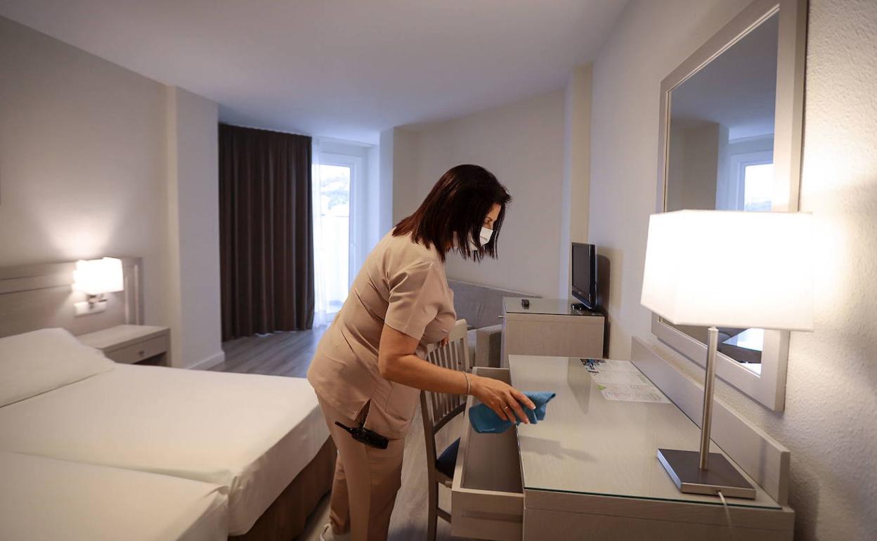 Una trabajadora limpia una habitación de hotel durante la pandemia. 