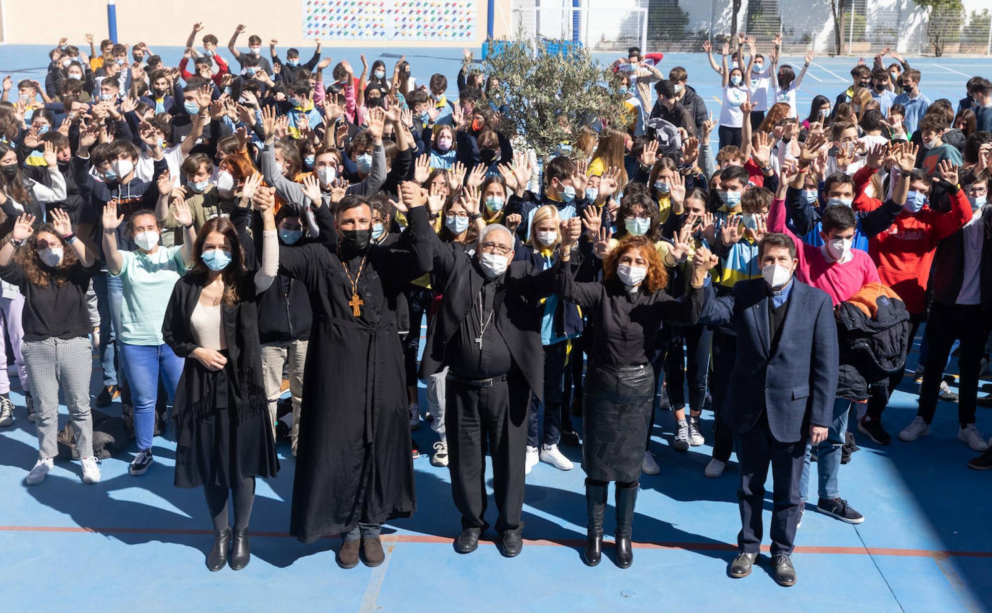 Los cuatro sacerdotes entrelazan sus manos (a la izquierda la traductora del ministro ortodoxo), junto al alumnado del colegio Virgen de Gracia.