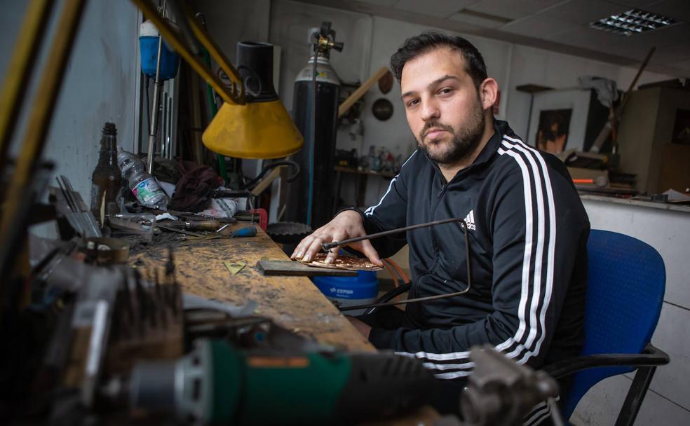 Manuel corta una pieza con la segueta en el taller del Albaicín. 